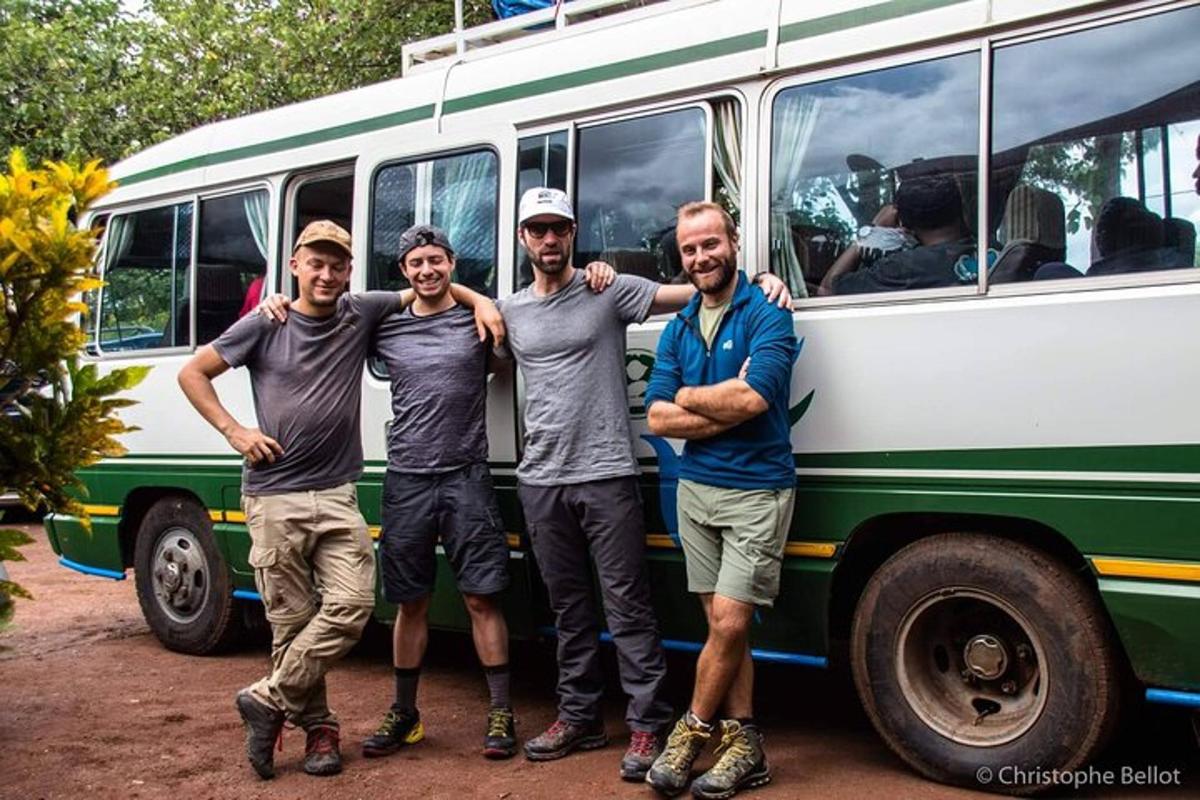 Un grupo de cuatro hombres de pie frente a un autobús.