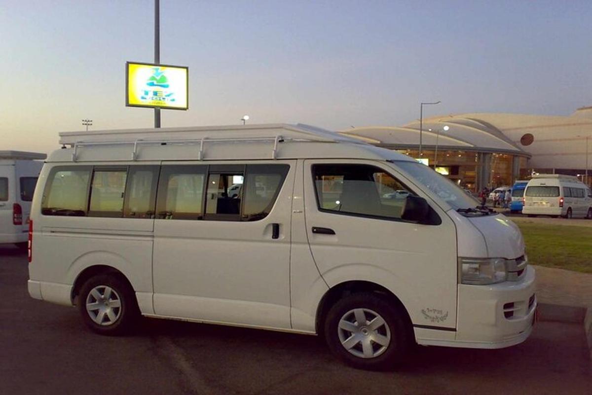 Una camioneta blanca estacionada en un estacionamiento con un cartel