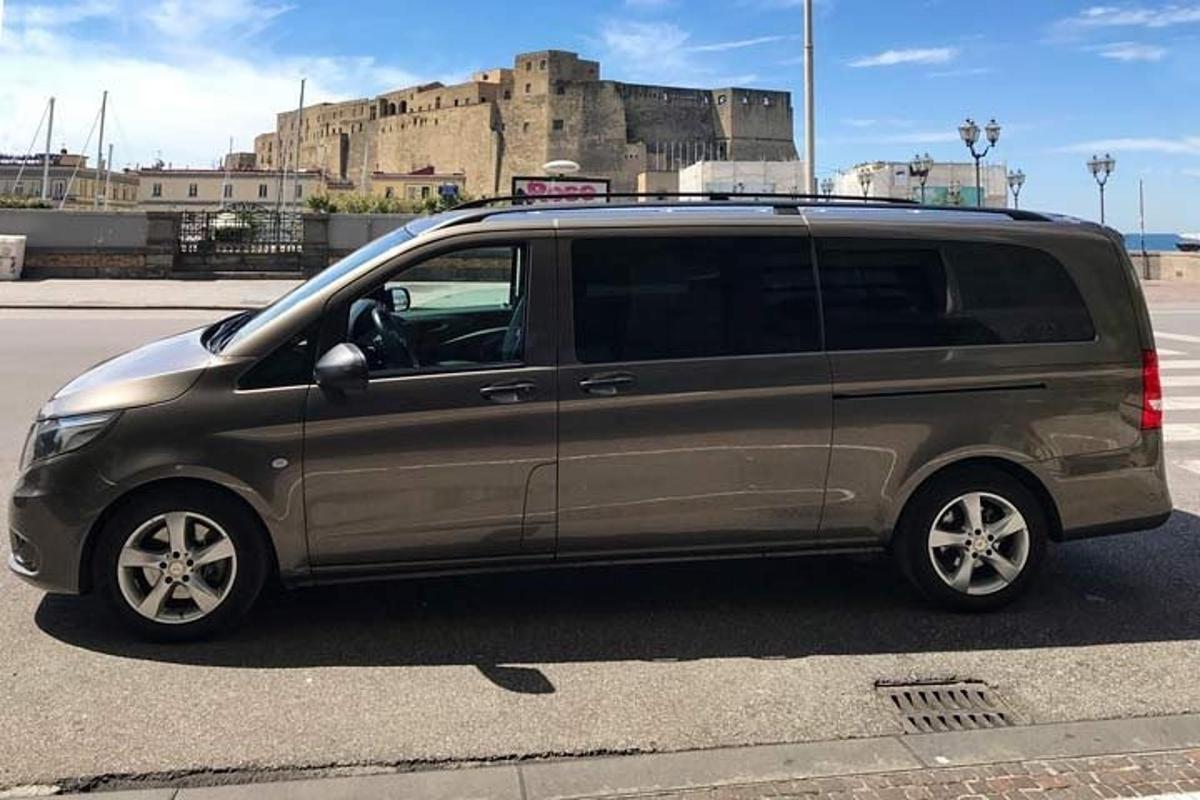 a van parked in a parking lot with a castle in the background