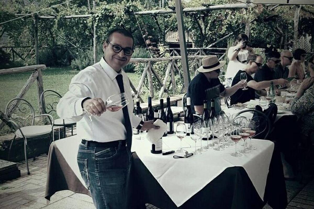 a man standing in front of a table with wine glasses