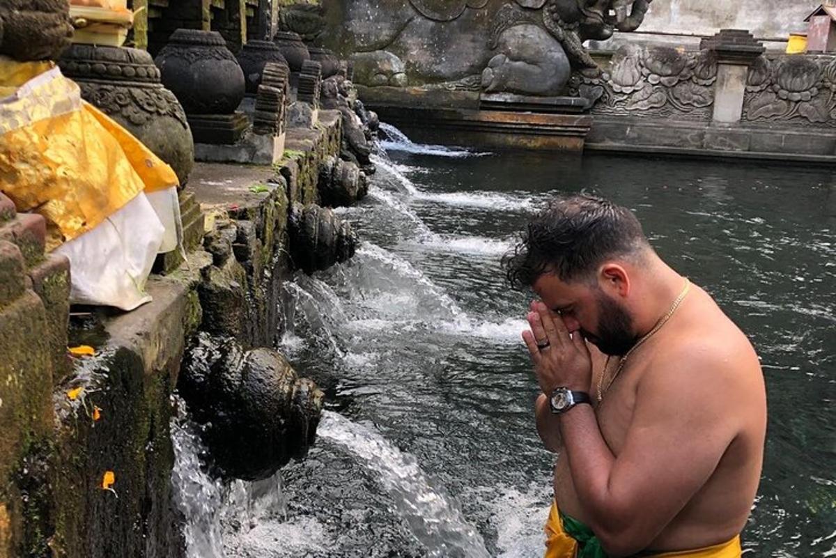 un hombre parado frente a una fuente de agua
