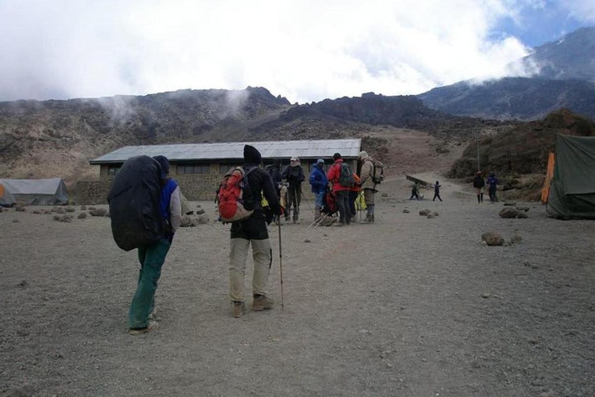 un gruppo di persone in piedi vicino a un edificio in montagna