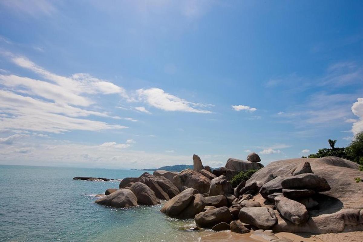 a group of rocks in the water on a beach