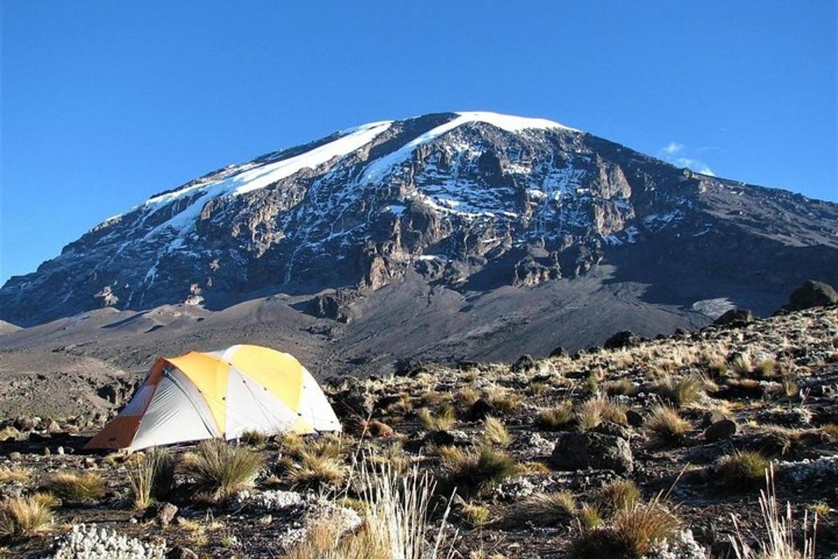 sebuah khemah di hadapan gunung yang dilitupi salji