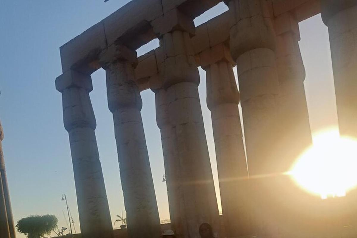 a view of a building with the sun behind it