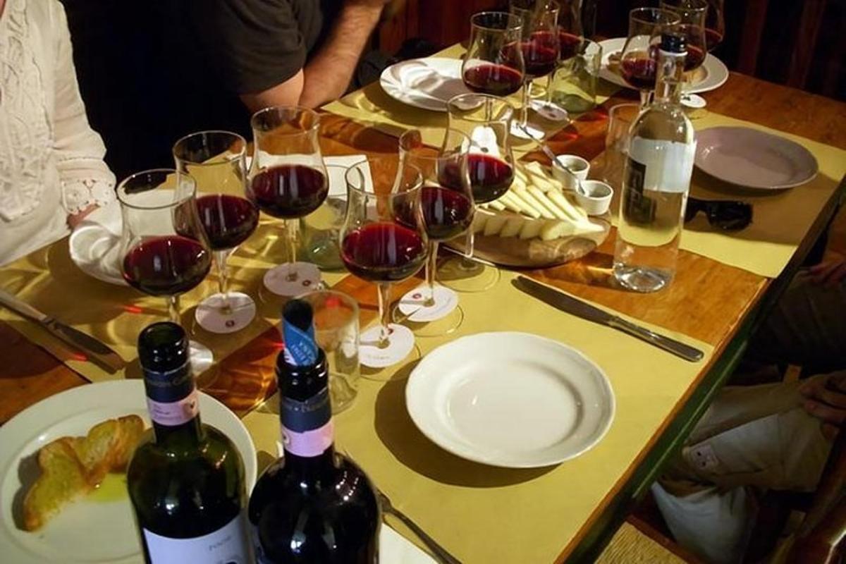 Una mesa con copas de vino y botellas de vino.