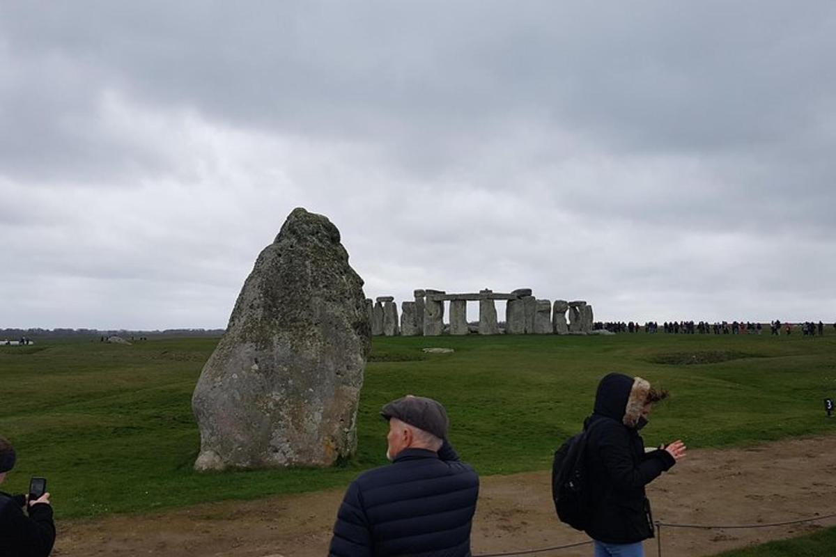 un gruppo di persone in piedi accanto a una grande roccia
