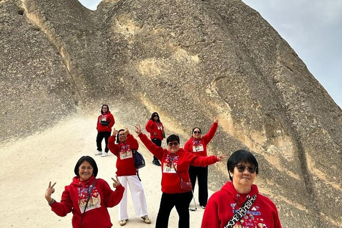 Un grupo de personas de pie frente a una roca