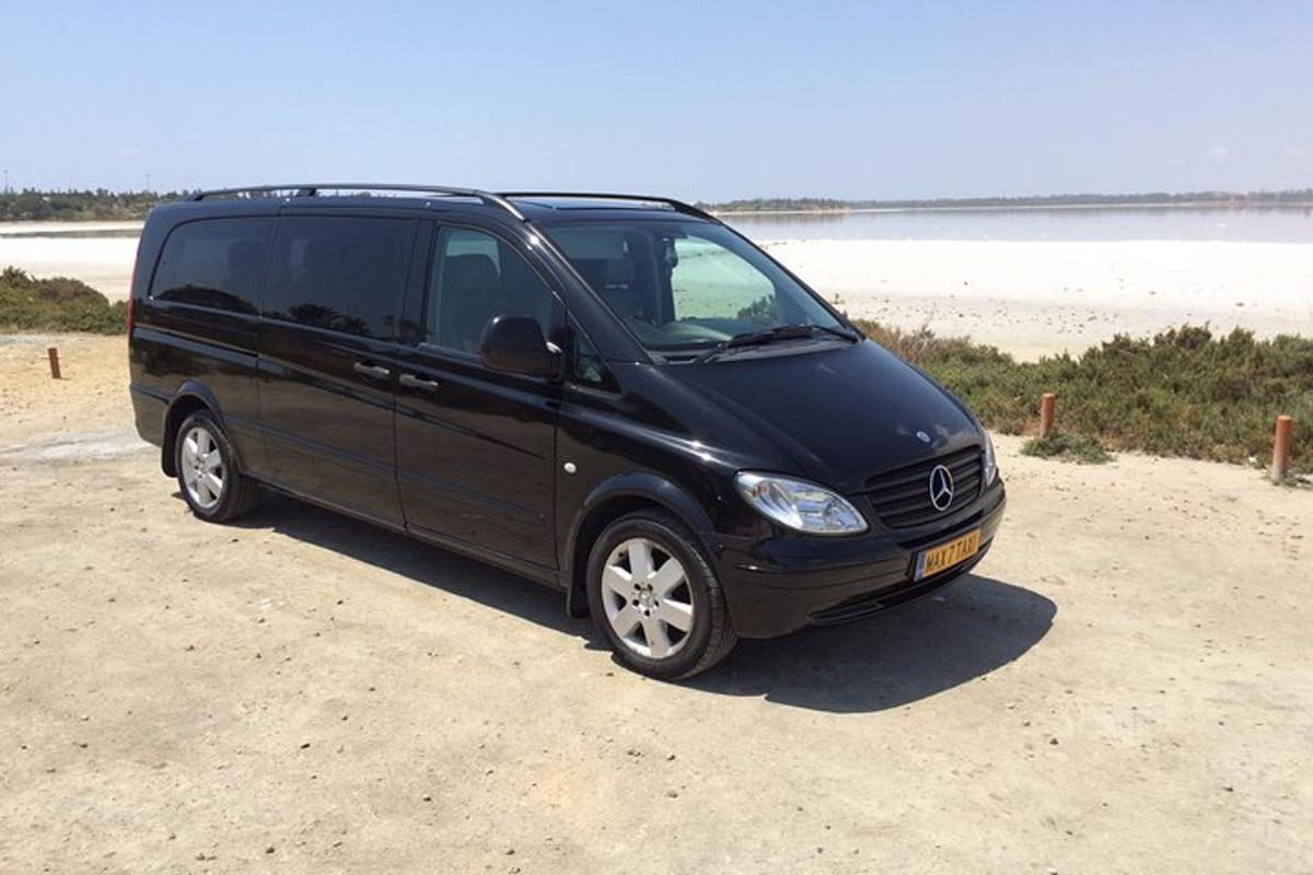 een zwarte bestelwagen geparkeerd op het zand vlakbij het strand