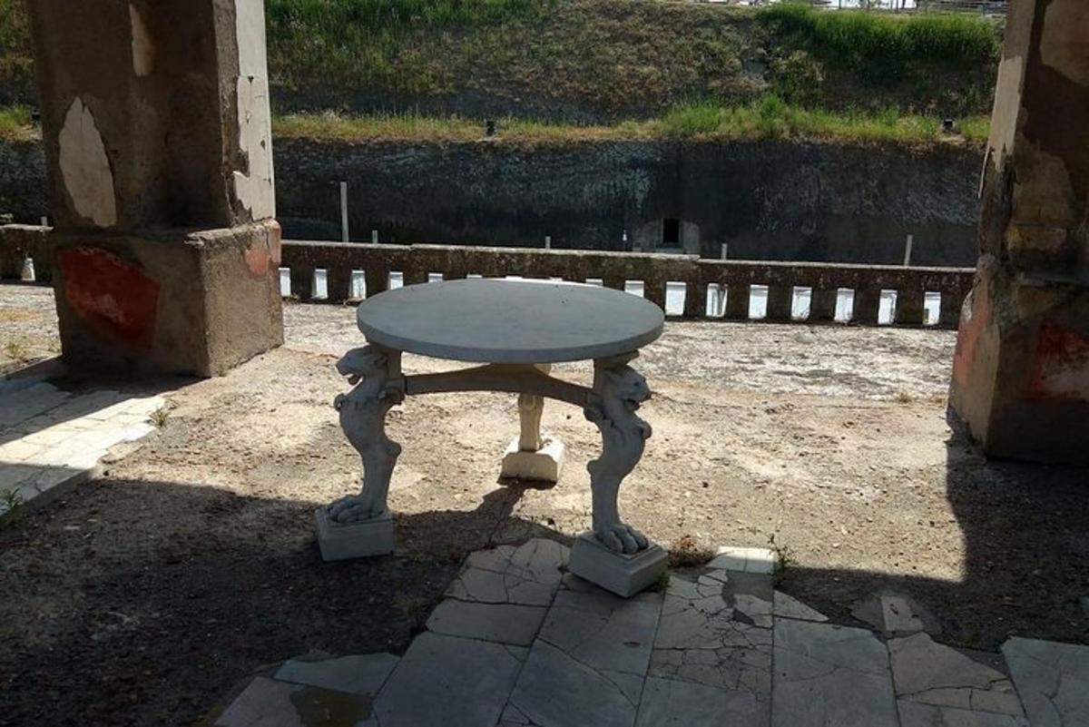 bir binanın gölgesinde oturan küçük bir masa