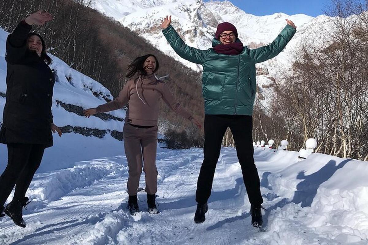 drei Frauen stehen mit erhobenen Armen im Schnee