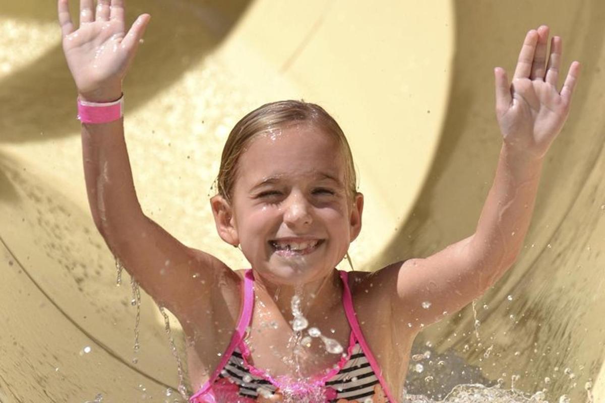 una ragazzina sta giocando su uno scivolo d'acqua