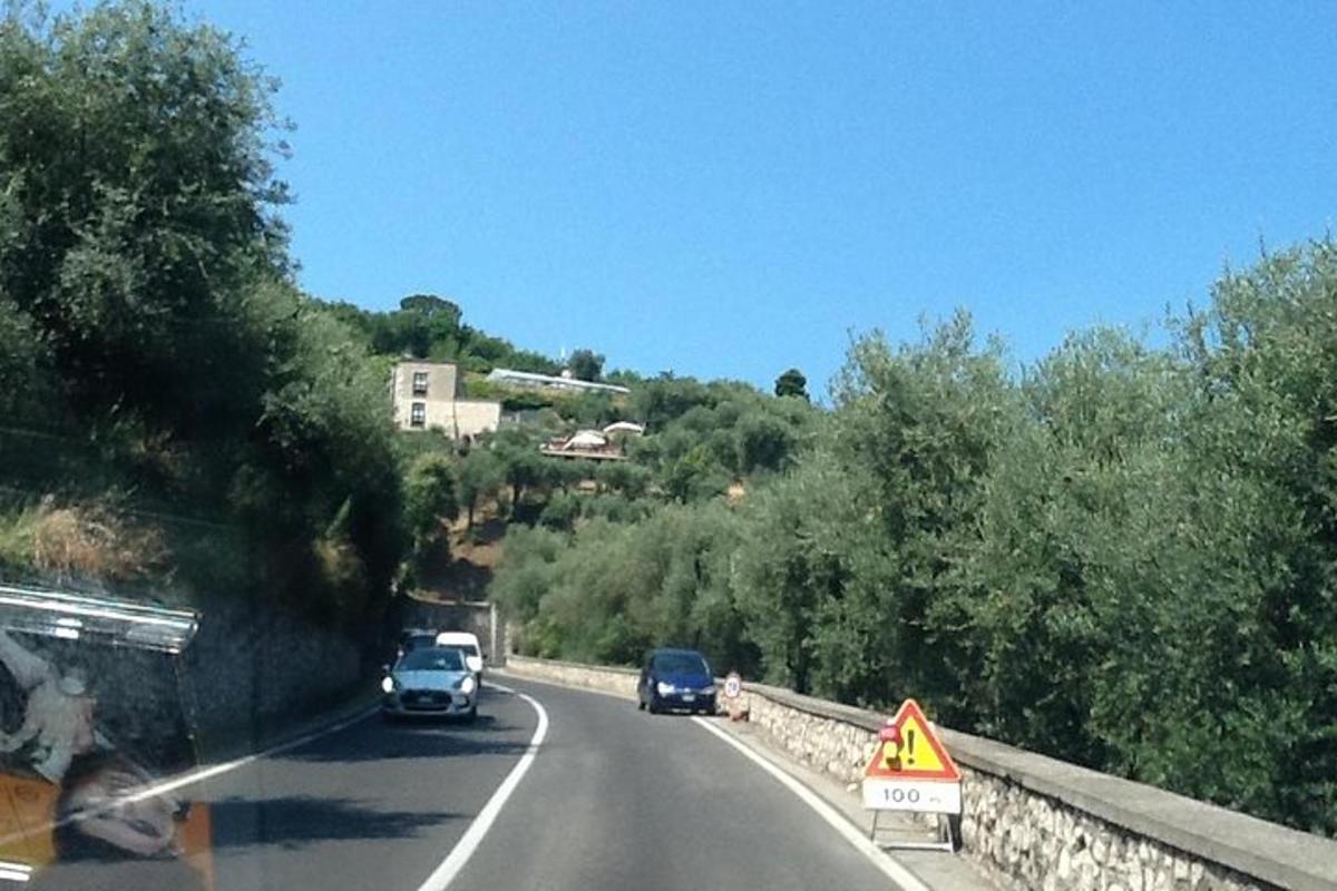 Una carretera con coches y un cartel al costado