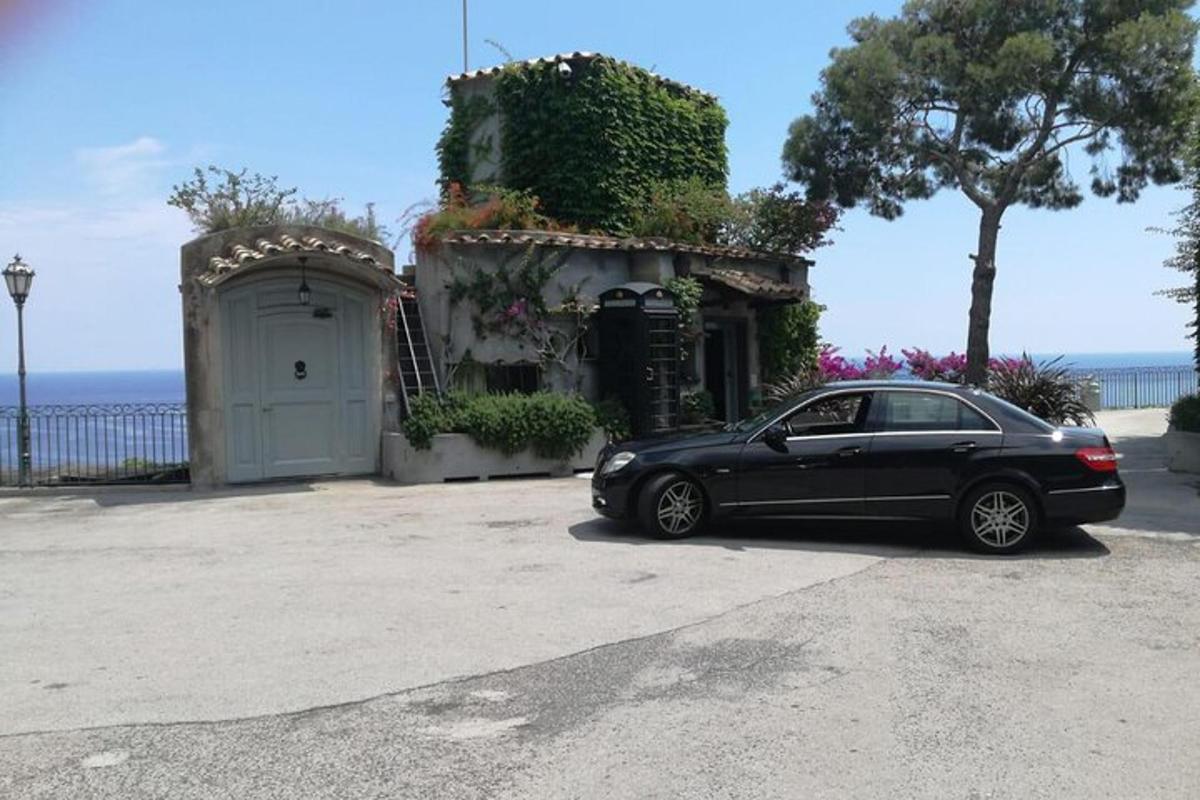 un'auto nera parcheggiata davanti a una casa