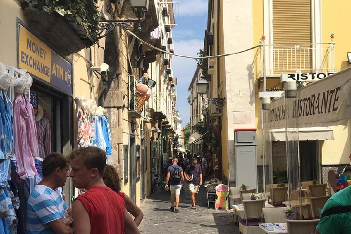 Un grupo de personas caminando por una calle con edificios.