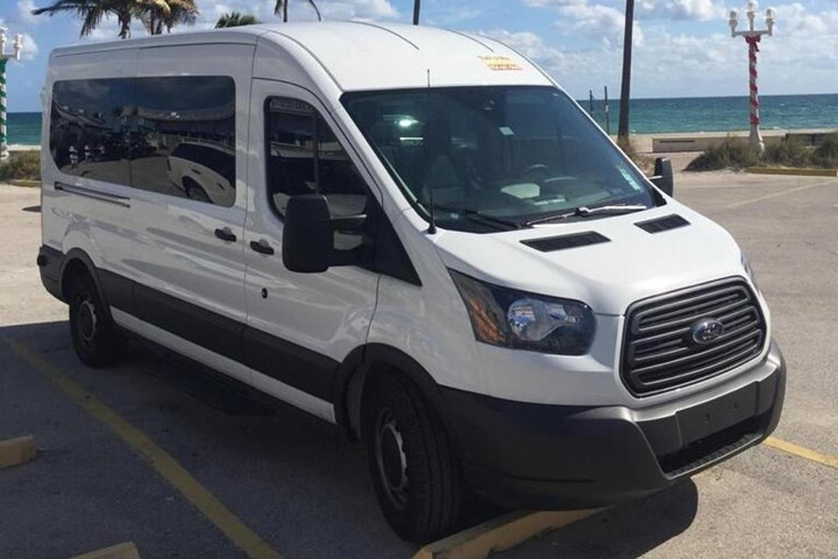 uma van branca estacionada em um estacionamento perto do oceano