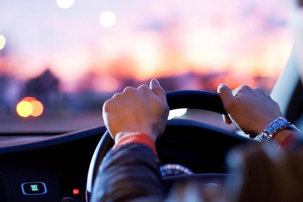 a person driving a car with their hands on the steering wheel