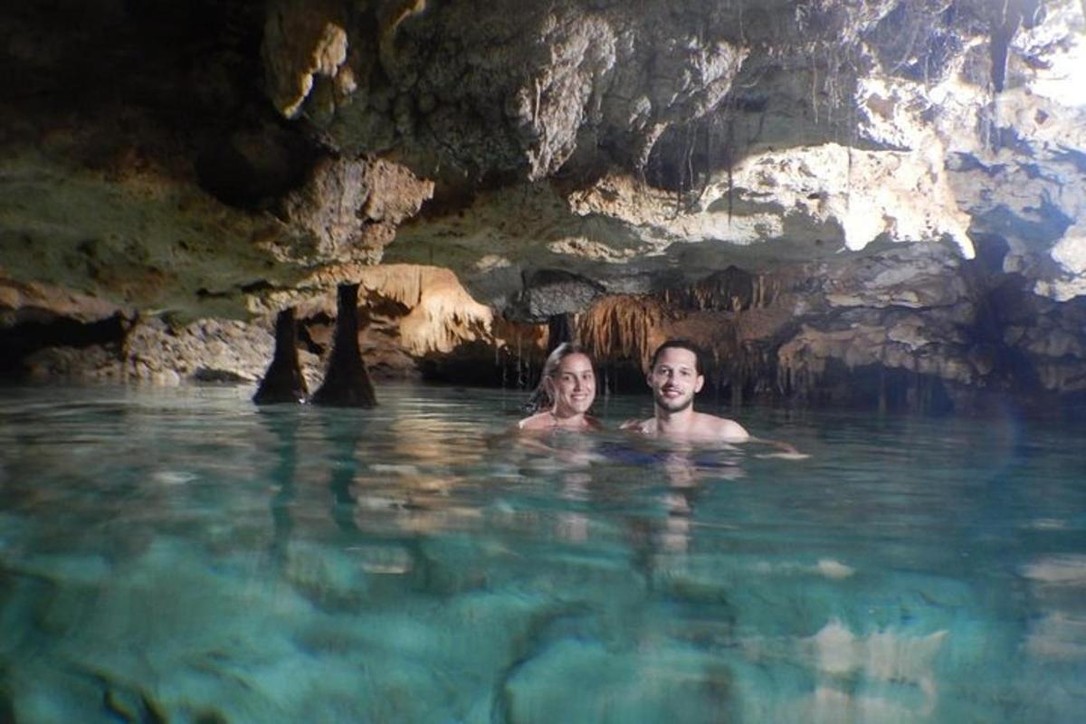 Dos personas nadando en el agua en una cueva.
