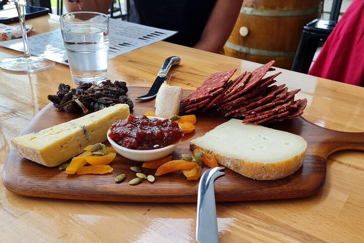un tagliere di legno con formaggio e altri alimenti su un tavolo