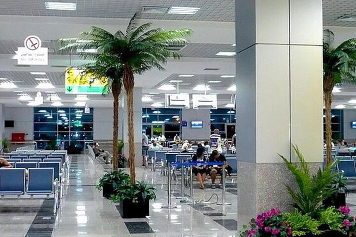 ένα εμπορικό κέντρο με φοίνικες και ανθρώπους που κάθονται σε τραπέζια