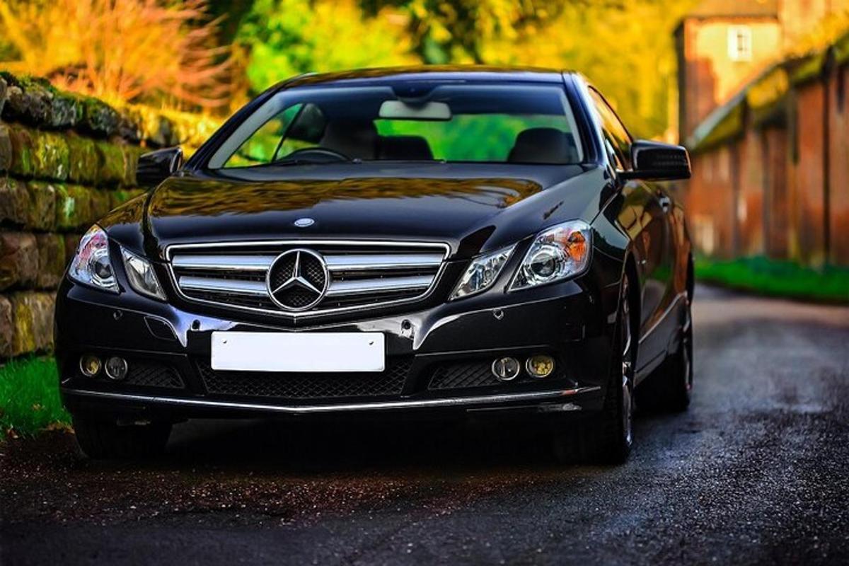 černé auto zaparkované vedle kamenné zdi