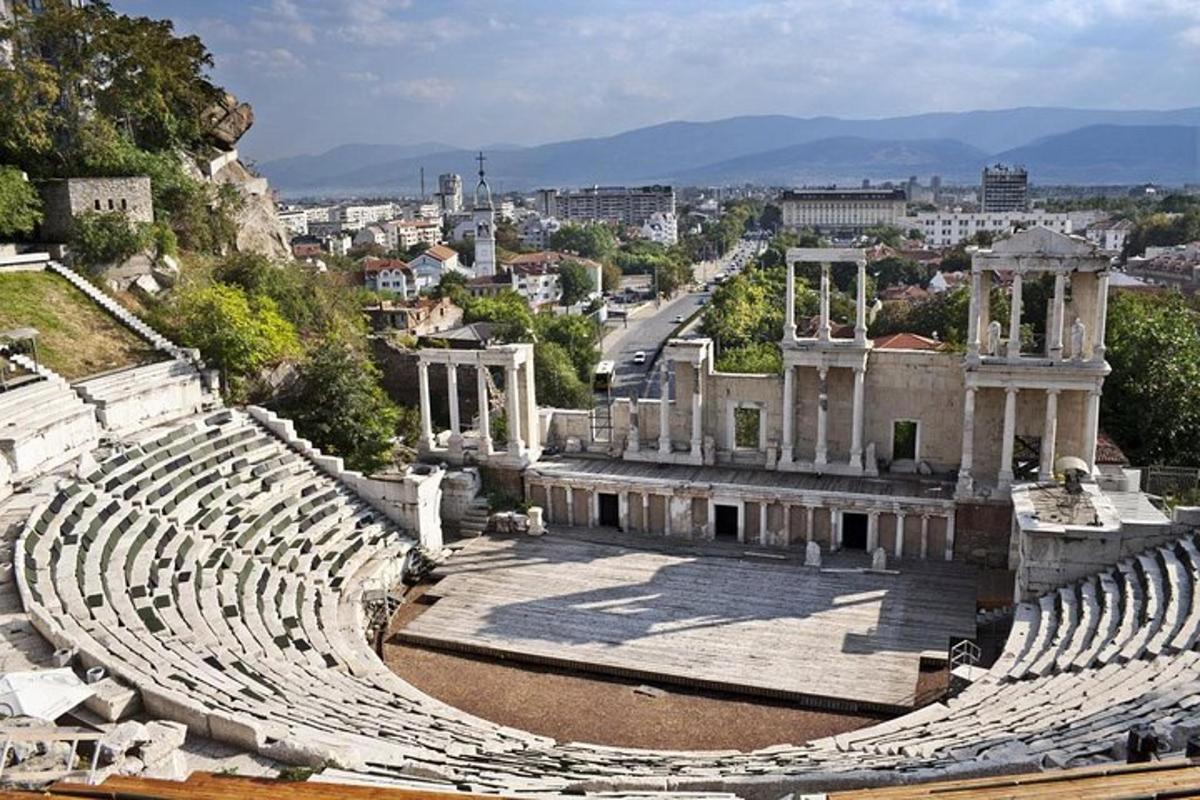 um anfiteatro vazio com uma cidade ao fundo