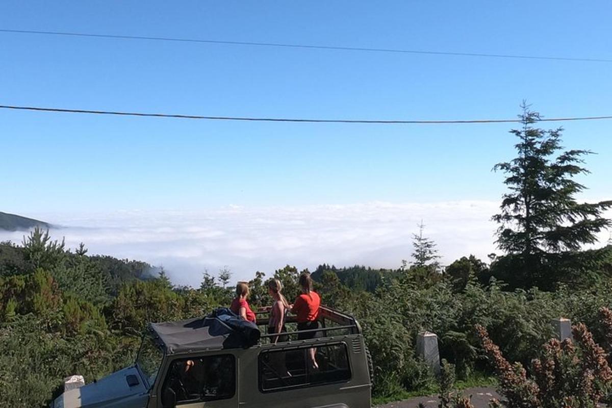 tiga orang berdiri di atas trak