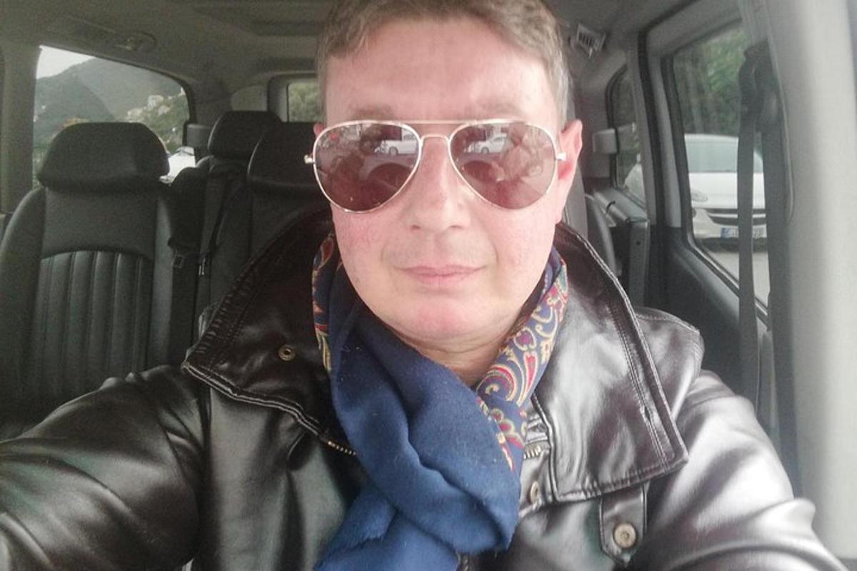 човек у кожној јакни и сунчаним наочарима у ауту
