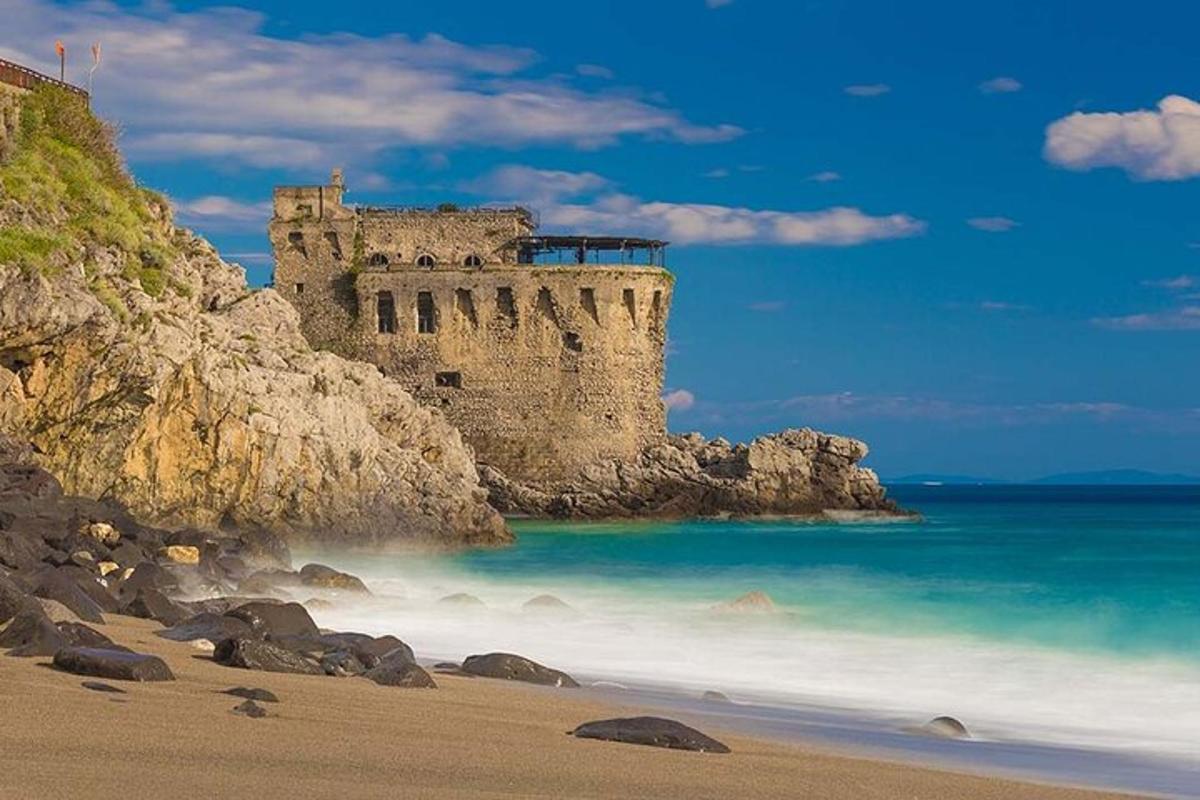 a castle sitting on top of a beach next to the ocean