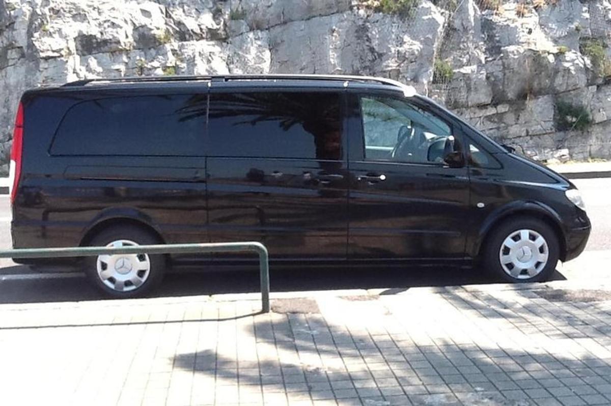 uma van preta estacionada na beira de uma rua
