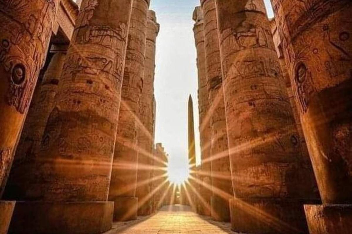 un sole splende attraverso le colonne di un antico edificio