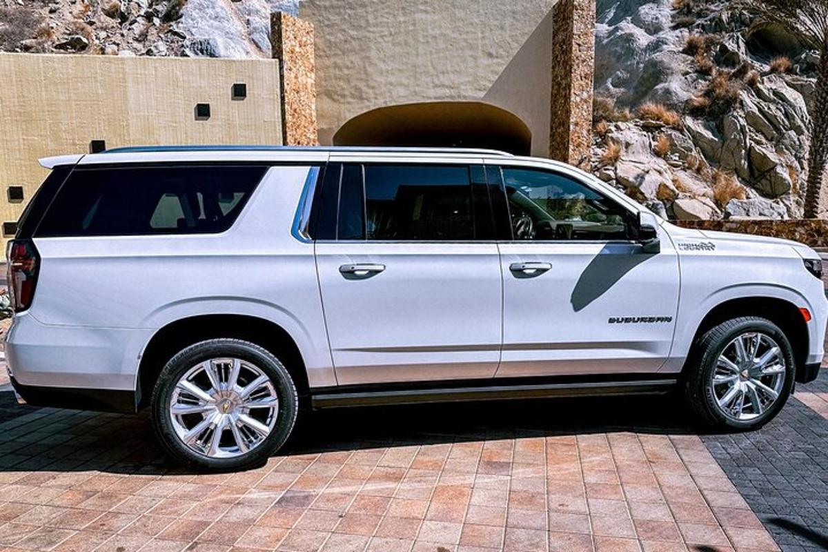 một chiếc xe suv màu trắng đỗ trước một tòa nhà