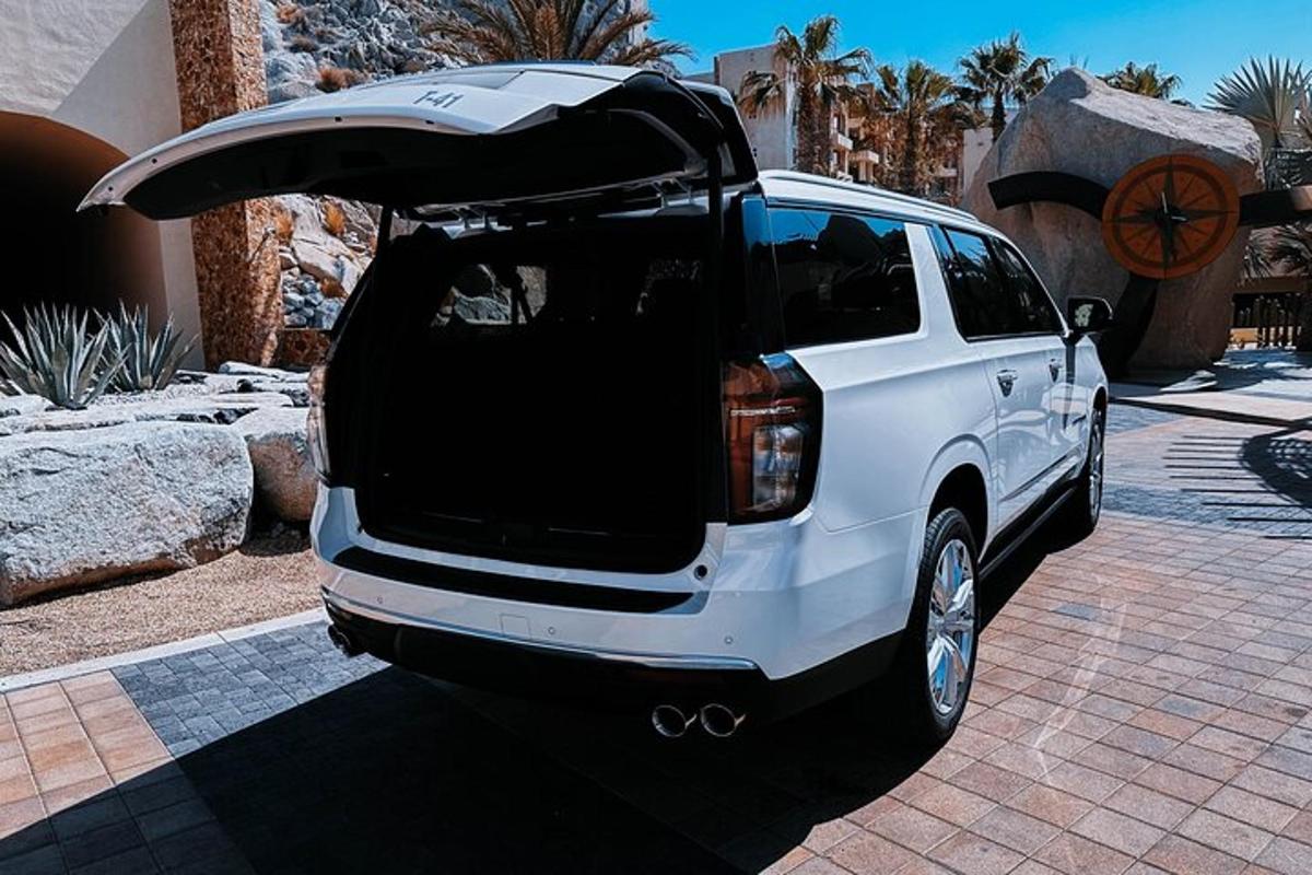 một chiếc xe SUV màu trắng với cốp xe mở trên đường lái xe