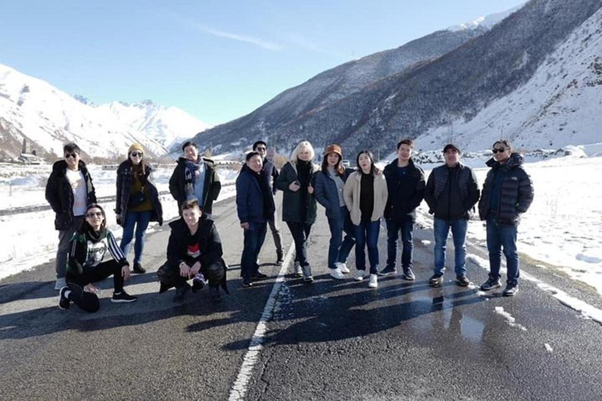 un gruppo di persone in piedi sul ciglio di una strada