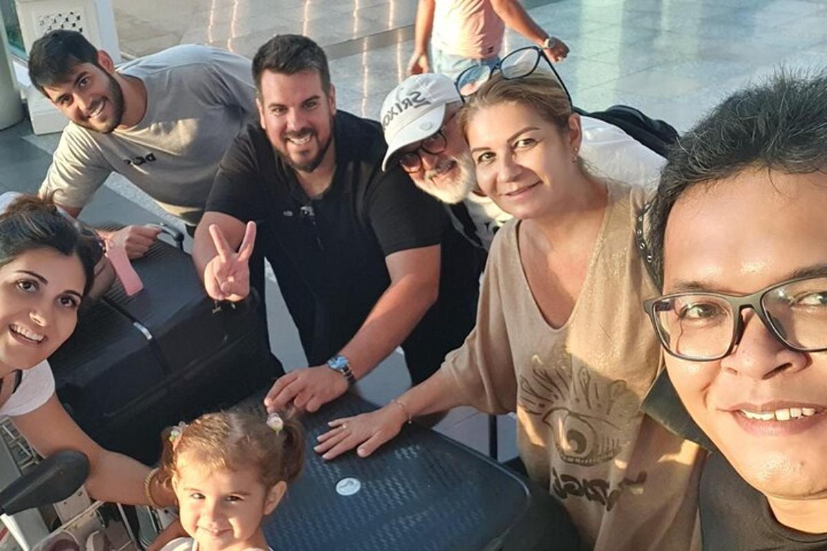 Un grupo de personas de pie alrededor de una mesa con un bebé.