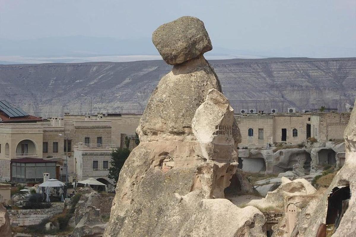 una estatua de una persona sentada en la cima de una roca