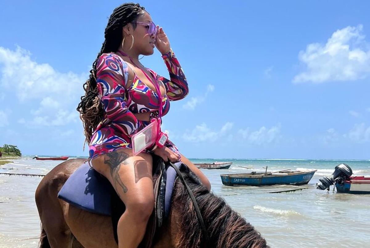 a woman sitting on a horse on the beach