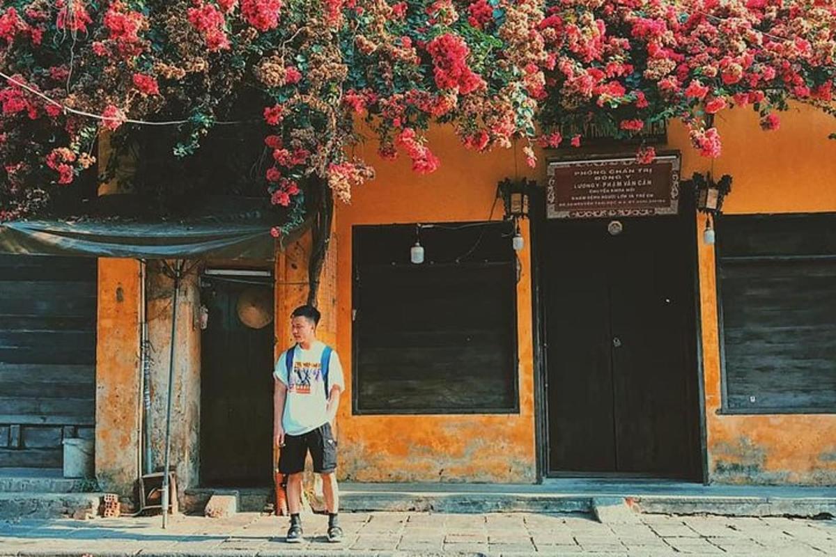 muž stojící před budovou s květinami