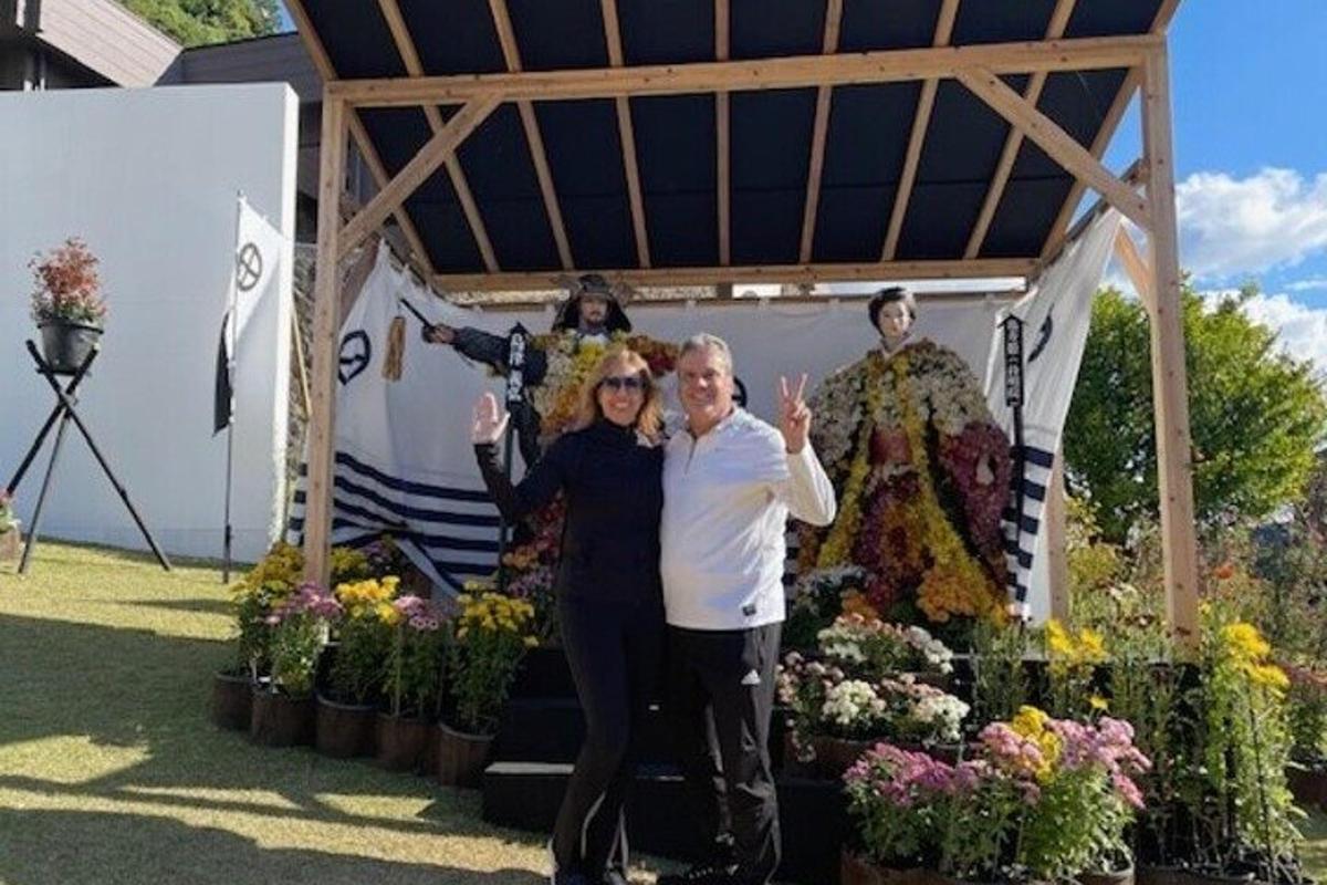 a man and woman standing in front of a display of flowers