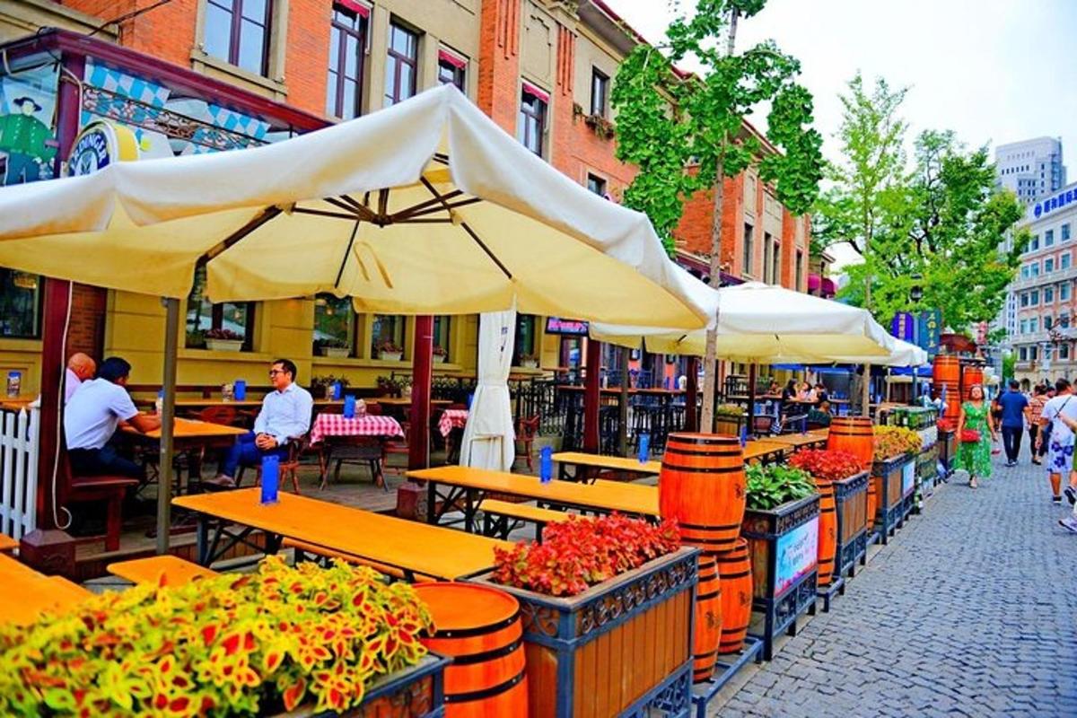 an outdoor market with tables and umbrellas on a street