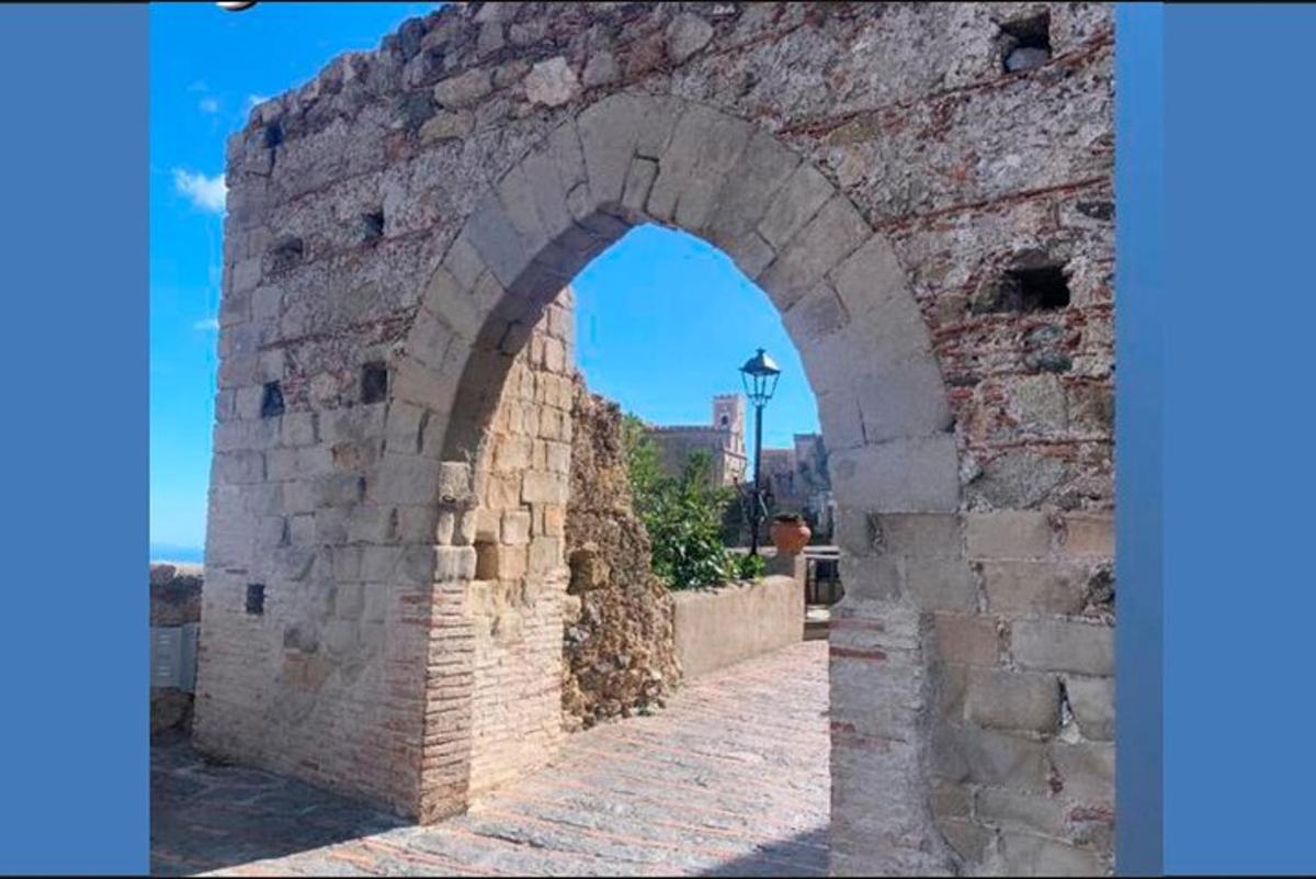 an archway in a brick wall with a street