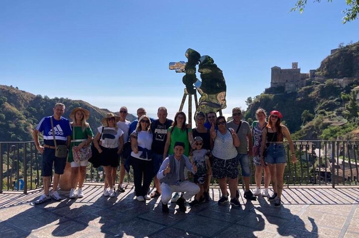 a group of people posing for a picture in front of a mountain