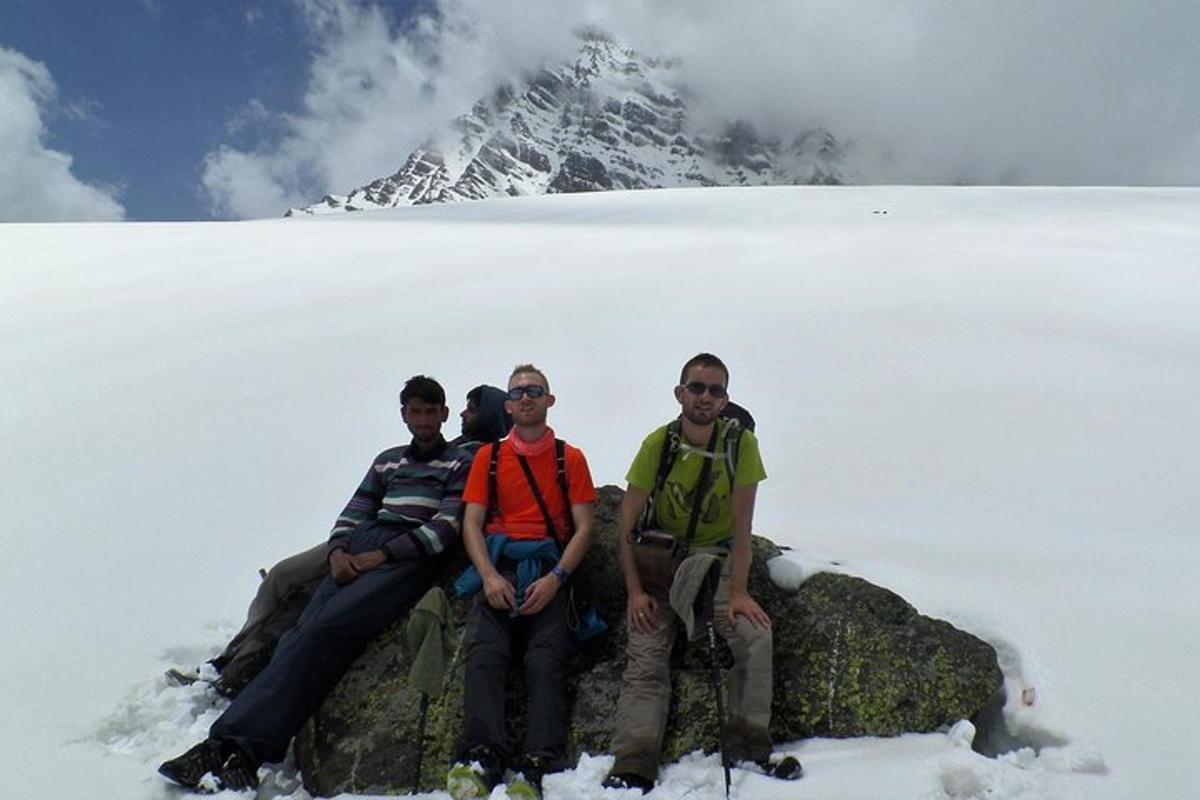 a group of people sitting on a rock in the snow