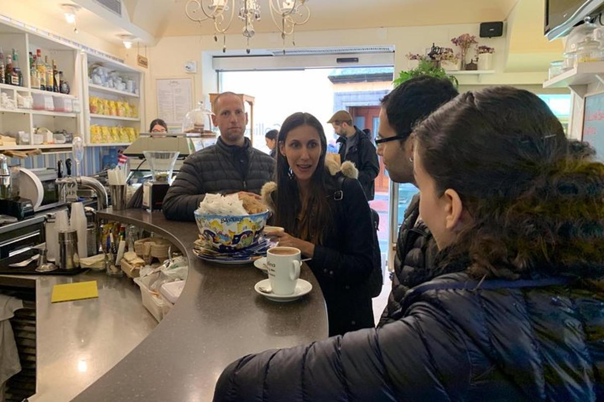 μια ομάδα ανθρώπων που στέκονται γύρω από έναν πάγκο σε μια καφετέρια