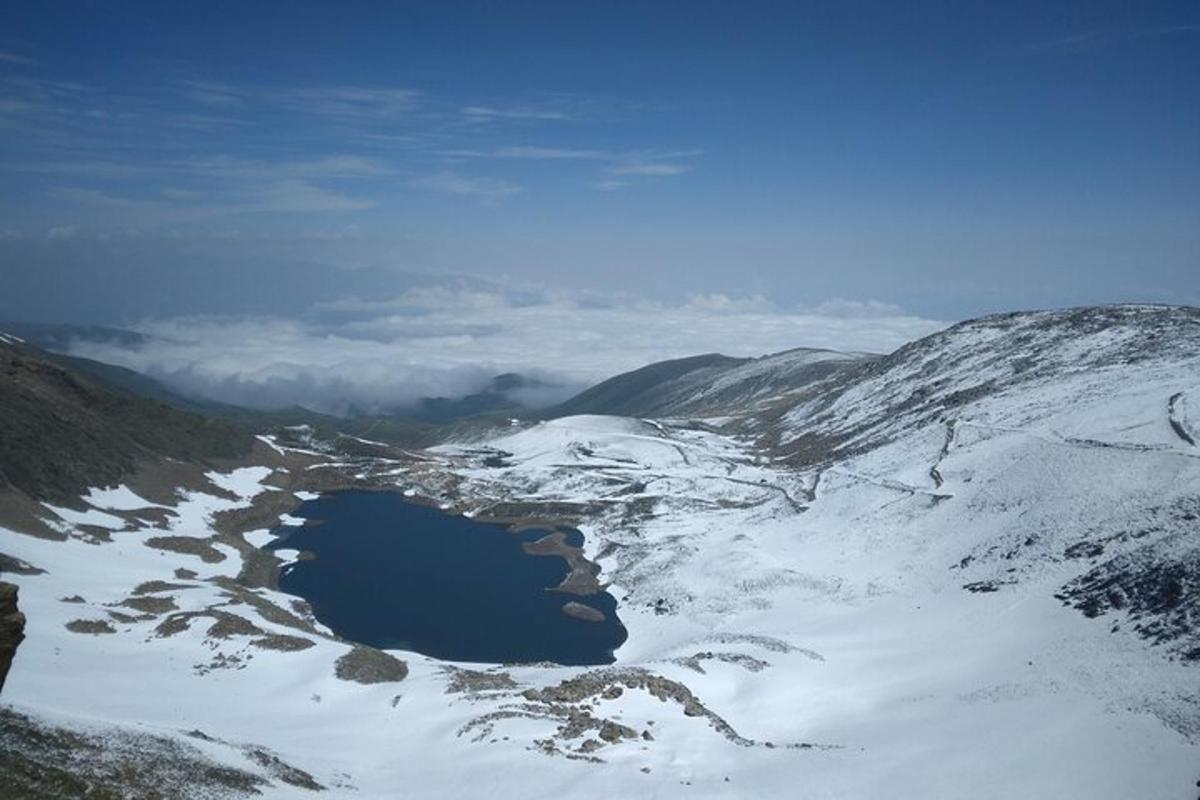 a lake in the snow on a snowy mountain