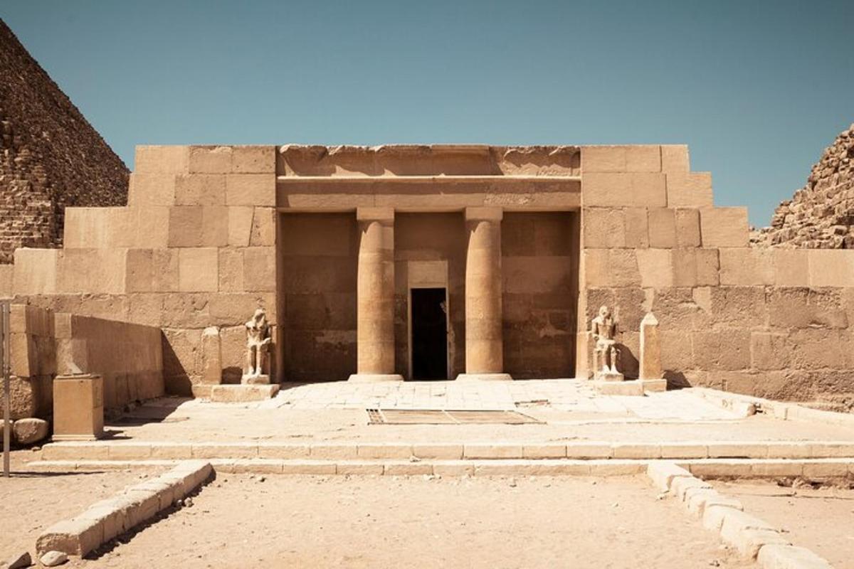 Un gran edificio de piedra con pilares y una puerta.