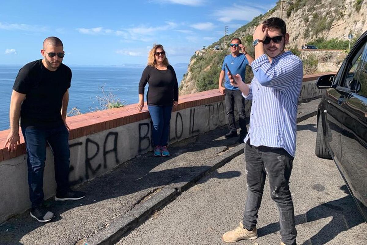 en gruppe mennesker som står på en vei nær havet