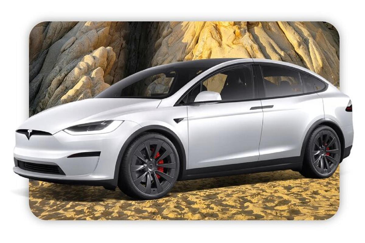 Hvítur Tesla bíll lagður fyrir framan vegg