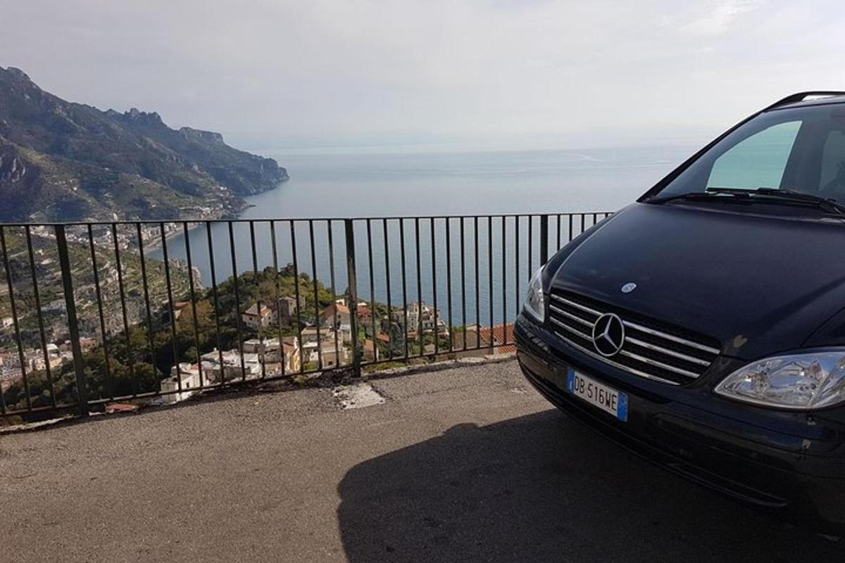 ein Auto, das auf der Seite eines Hügels mit Blick auf den Ozean geparkt ist