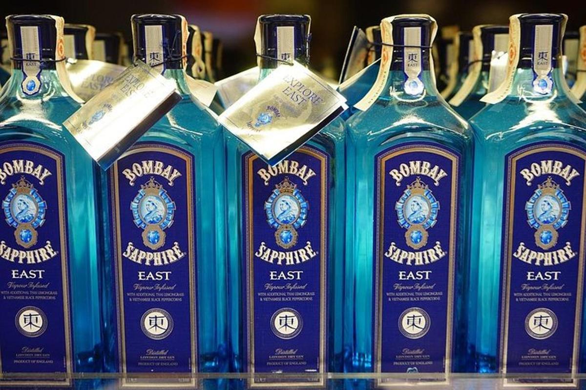 Un grupo de botellas de ginebra azules en un estante.